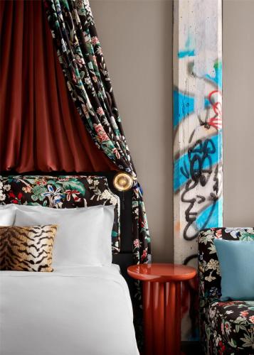 a bedroom with a bed and a red curtain at The Radical Asheville, Tapestry Collection by Hilton in Asheville
