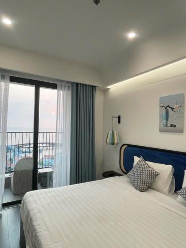 a hotel room with a bed and a balcony at Hillside apartment sunset town city in Phu Quoc