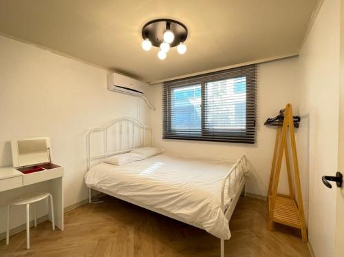 a bedroom with a bed and a desk and a window at Iee Sang House Room 3, 4 queen beds #COEX #Plastic surgery #Hospital #Lotte World #Free parking #Family #Friends in Seoul