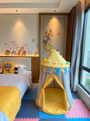 a bedroom with a bed and a play tent at Shangrao International Hotel in Shangrao