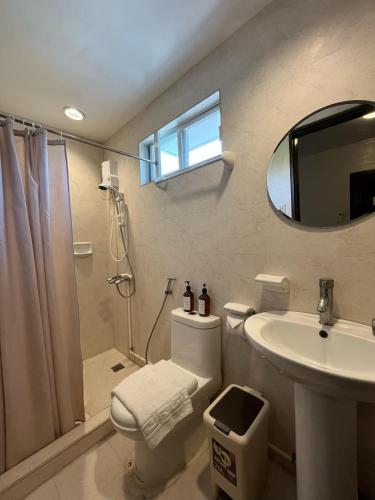 a bathroom with a toilet and a sink and a mirror at Gabi Villa in San Juan