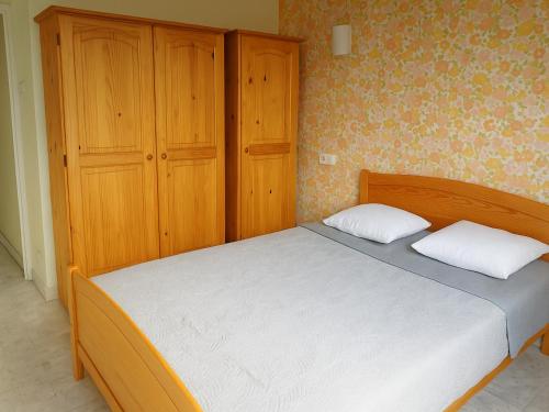 une chambre avec un lit et une armoire en bois dans l'établissement T2 lumineux au Racou avec piscine et parking, 100m de la plage - Argelès-sur-Mer - FR-1-732-7, à Argelès-sur-Mer