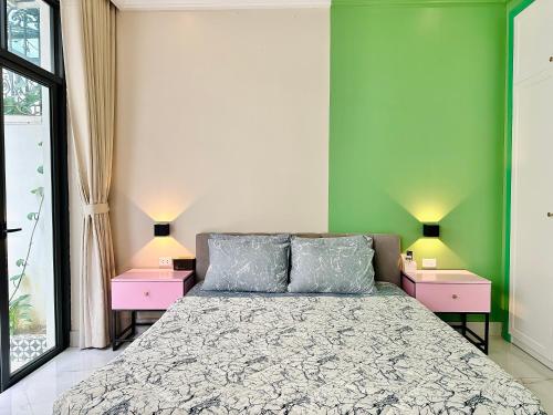 a bedroom with green walls and a bed with two night stands at ANVI HOUSE - Vinhomes Marina Hải Phòng in Xóm Niêm