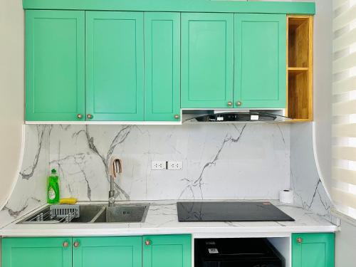 a kitchen with mint green cabinets and a sink at ANVI HOUSE - Vinhomes Marina Hải Phòng in Xóm Niêm