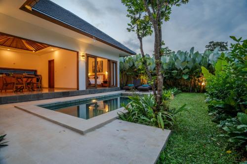 a backyard with a swimming pool and a house at Arca Jungle View Luxury Villa Ubud in Ubud
