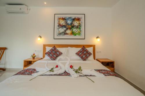 a bedroom with a white bed with two weddingbons at Arca Jungle View Luxury Villa Ubud in Ubud