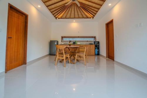 a dining room with a wooden table and chairs at Arca Jungle View Luxury Villa Ubud in Ubud