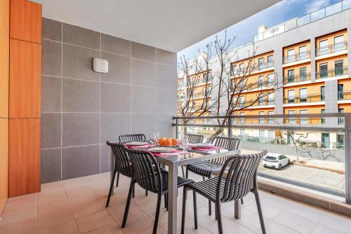 a dining room with a table and chairs and a window at Olhão Beach Apartment in Olhão