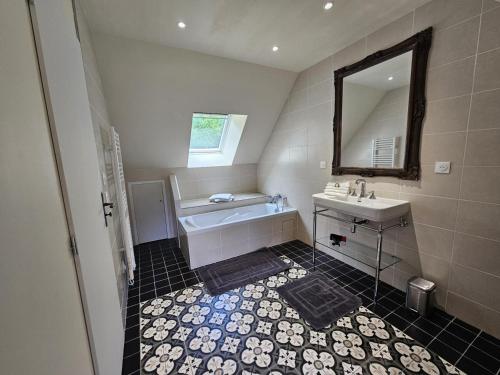 un bagno con vasca, lavandino e specchio di Charmant gîte champêtre avec bain nordique et terrasse privative - FR-1-491-441 a Fresnes