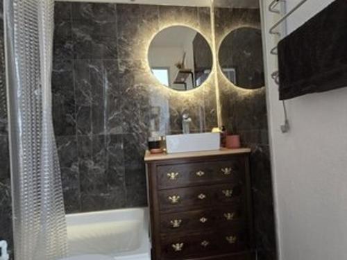 une salle de bain avec un lavabo, un miroir et une baignoire dans l'établissement Appartement Bord de Mer avec Parking et Piscine - Confort et Commodité - FR-1-801-4, au Cap d'Agde