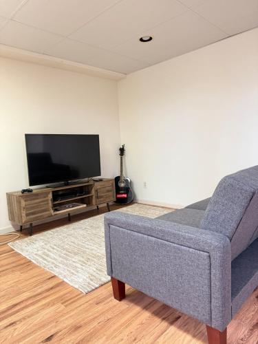 a living room with a couch and a flat screen tv at Cozy Ithaca Retreat - Fenced Yard - 7 min to Cornell in Ithaca
