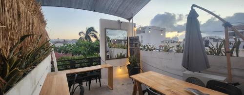 a balcony with a table and chairs and a window at HOM Hostel Boutique in Playa del Carmen