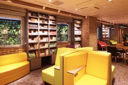 a library with yellow chairs and books at 鳥取グリーンホテルモーリス in Tottori