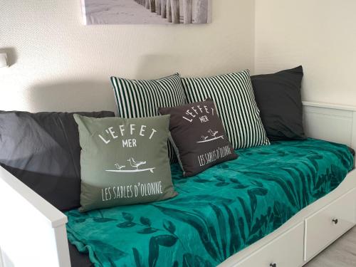 un canapé avec des coussins dessus dans un salon dans l'établissement Studio 2 personnes accès direct plage - FR-1-197-624, à Les Sables-dʼOlonne
