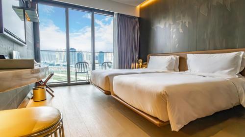 a bedroom with a large bed and a large window at YOHO Hollywood Roosevelt Hotel in Macau