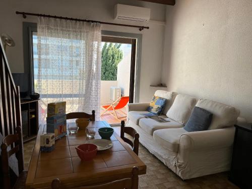 un salon avec un canapé blanc et une table dans l'établissement Villa Climatisée 6 Pers - Proche Port & Village - Parking Privé - FR-1-796-88, à Gruissan