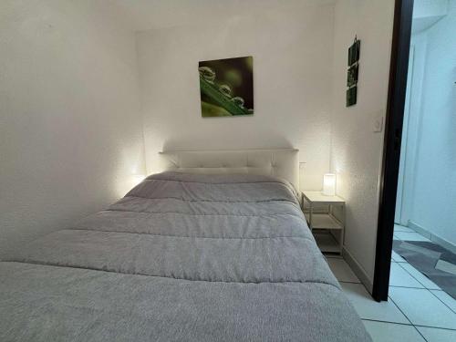 Ce lit se trouve dans une chambre blanche dotée d'un lit sidx sidx. dans l'établissement Appartement 2 pièces avec terrasse et vue piscine à Cannes la Bocca - FR-1-609-112, à Cannes