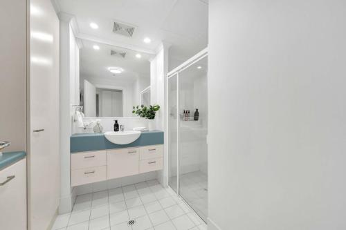 a white bathroom with a sink and a shower at Sub-Penthouse with Marina View by Host Solutions in Glenelg