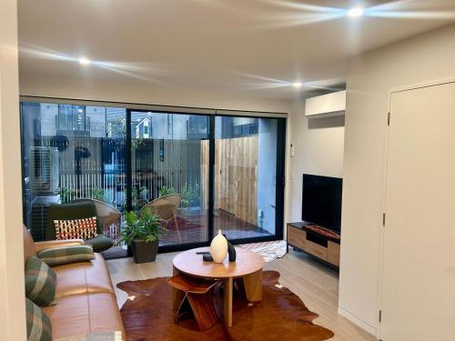 a living room with a couch and a table at Two Units - 4 Bedrooms - 4 Bathrooms in Christchurch