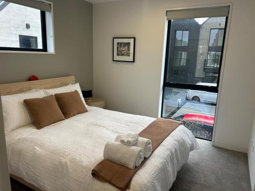 a bedroom with a large bed with towels on it at Two Units - 4 Bedrooms - 4 Bathrooms in Christchurch