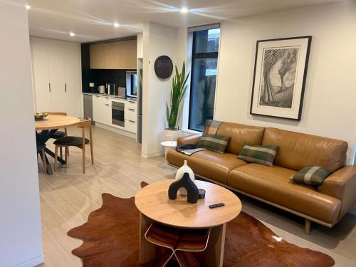 a living room with a couch and a table at Two Units - 4 Bedrooms - 4 Bathrooms in Christchurch