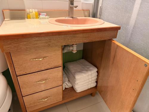 a bathroom vanity with a sink and towels under it at Cerca Foro Sol GNP y Aeropuerto in Mexico City