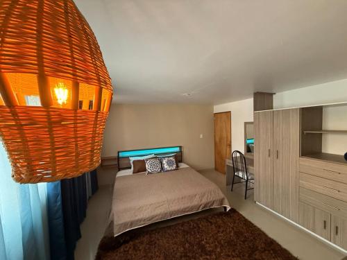 a bedroom with a bed and a chandelier at Cerca Foro Sol GNP y Aeropuerto in Mexico City