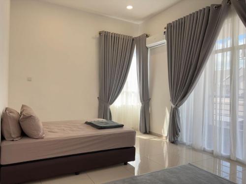 une chambre avec un lit et une grande fenêtre dans l'établissement Olive Homestay SP Saujana 5 Bedrooms 6 Toilets Mus lim Friendly, à Sungai Petani