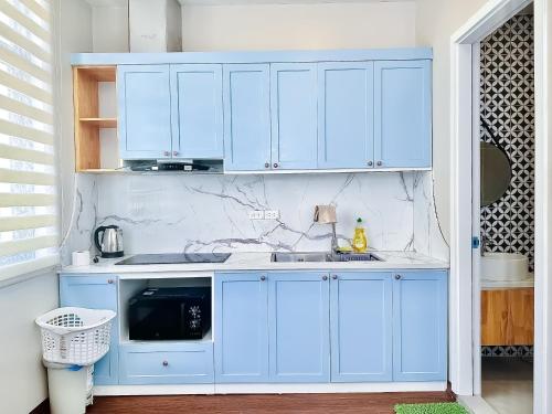a kitchen with blue cabinets and a sink at ANVI HOUSE - Vinhomes Marina Hải Phòng in Xóm Niêm