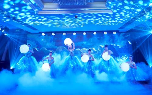 Un grupo de mujeres con vestidos azules en un escenario. en Paradise Suites Hotel, en Ha Long