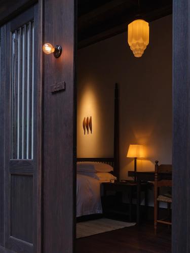 a bedroom with a bed and a lamp and a mirror at Lansheng yard in Xiamen
