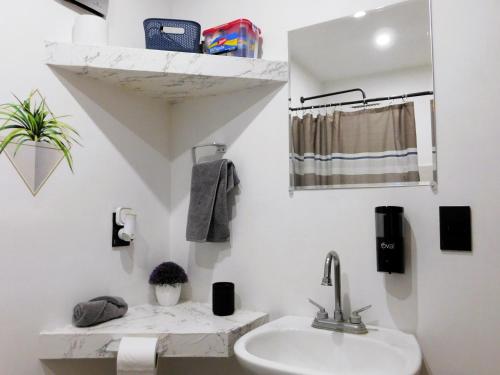 a white bathroom with a sink and a mirror at Depa privado Estadio GNP -Foro Sol-, Palacio de los Deportes in Mexico City