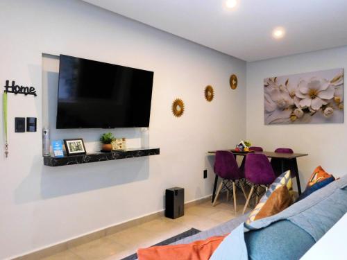 a living room with a large flat screen tv on the wall at Depa privado Estadio GNP -Foro Sol-, Palacio de los Deportes in Mexico City