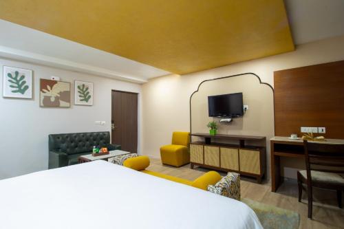 a hotel room with a bed and a living room at Alps Resort in Dalhousie