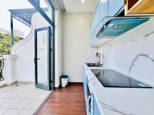 a kitchen with white countertops and a glass door at ANVI HOUSE - Vinhomes Marina Hải Phòng in Xóm Niêm