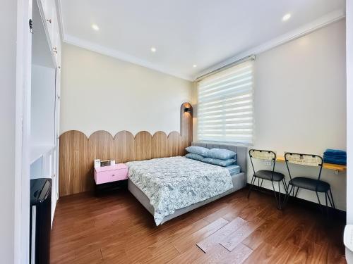 a bedroom with a bed and two chairs at ANVI HOUSE - Vinhomes Marina Hải Phòng in Xóm Niêm