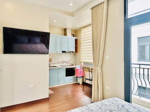 a small kitchen with blue cabinets and a window at ANVI HOUSE - Vinhomes Marina Hải Phòng in Xóm Niêm