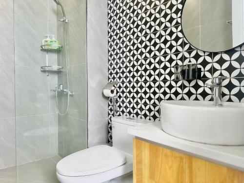 a bathroom with a toilet and a sink and a mirror at ANVI HOUSE - Vinhomes Marina Hải Phòng in Xóm Niêm