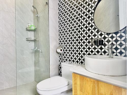 a bathroom with a toilet and a sink and a mirror at ANVI HOUSE - Vinhomes Marina Hải Phòng in Xóm Niêm