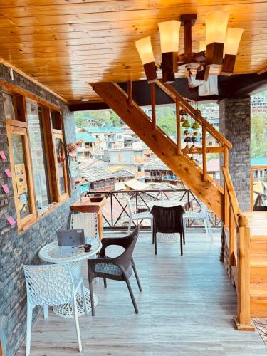 a patio with chairs and a table and a staircase at The Hamlet Stay in Manāli