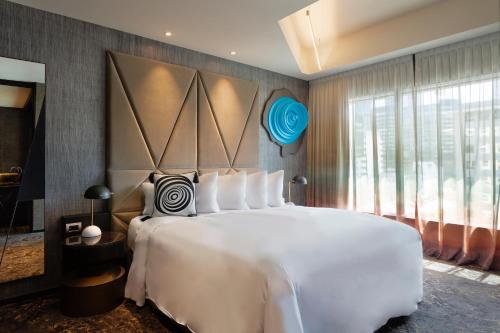 a bedroom with a large white bed and a large window at SO/ Auckland in Auckland
