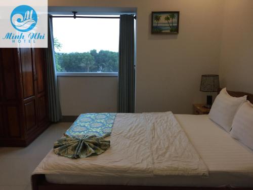 a bedroom with a bed and a window with a bow on it at Minh Nhi Hotel in Tân Tạo