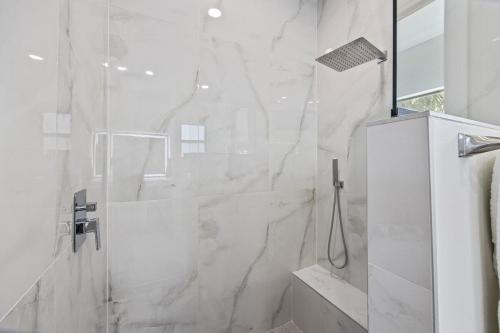 a white bathroom with a shower and a sink at Modern Waterfront Bliss in Port Charlotte