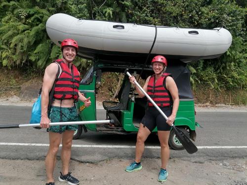 two people are standing in front of a golf cart at Eco Cabins Kitulgala in Kitulgala