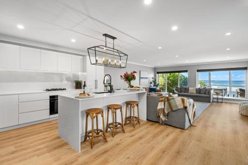 a kitchen with a large island with bar stools at The Jetty Huskisson in Huskisson