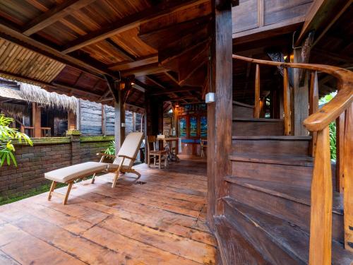 a porch of a wooden house with chairs on it at Aruna Jayanti Villa in Tejakula