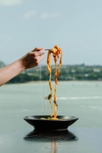 a person is eating food in a black bowl at SO/ Auckland in Auckland