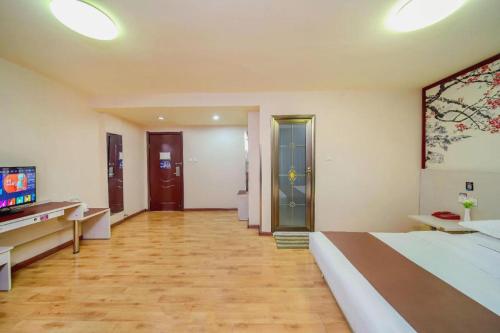 a large room with a bed and a television at Kunlun Leju Business Hotel Kaifeng Gulou in Kaifeng