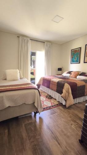 a bedroom with two beds and a window at Aconchego da Serra com Hidro Vista e Conforto Total in Gonçalves