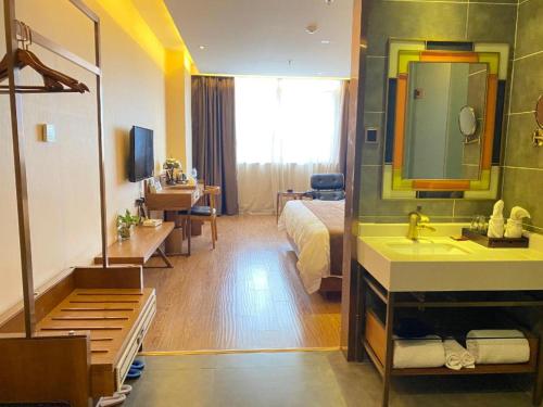 a bedroom with a bed and a bathroom with a sink at James Joyce Coffetel Hefei High-speed Railway South Station Branch in Hefei